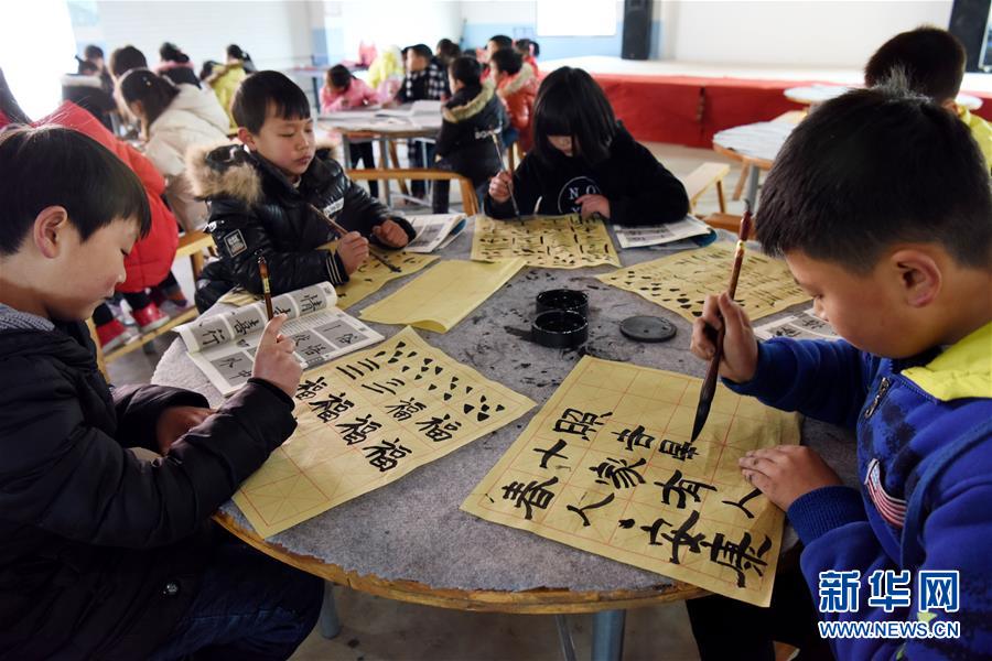 2月5日,初一学生胡锦宇(右)等在公益学堂学习毛笔书法.