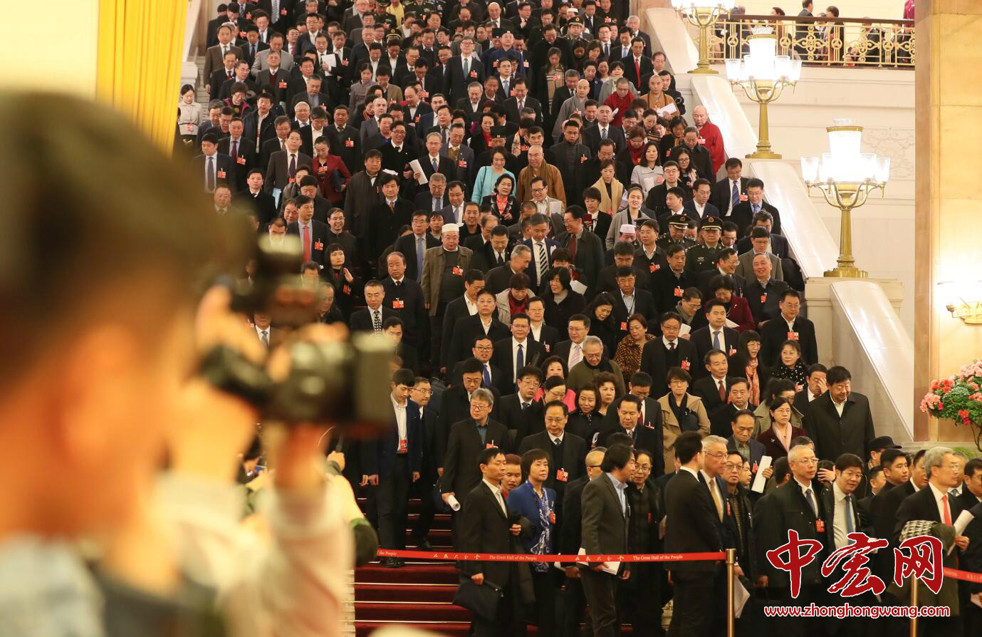 十三届全国人大一次会议开幕会结束后，出席会议的人大代表、列席会议的政协委员和有关部门负责人等离开会场。（摄影：张松峰）