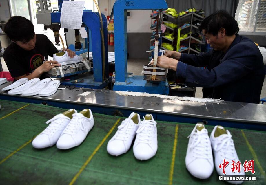 有“中国鞋城”之称的福建省莆田市，早从上世纪80年代开始，便开始为国际知名品牌代工，如今仍是耐克、阿迪达斯、安德玛、安踏等海内外中高端品牌的重要代工基地。图为莆田一家鞋企生产线上工人们在生产代工运动鞋。最近几年，莆田为国际品牌代工的订单越来越多。