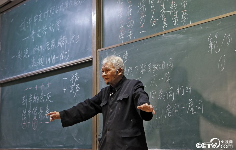 央视网消息:2018年3月15日,西安,94岁的网红教授潘鼎坤再次站上讲台,为同学们讲述中文对联的规律和魅力。潘鼎坤走进教室第一件事就是把放在讲台后面的椅子搬到了讲台旁边,并且全程站着讲了两个小时。讲课时,同学们惊叹老教授整齐的板书和清晰的思路,上课中,潘鼎坤自己一边擦黑板还一边给同学们说怎样才能将黑板擦得更干净,令人钦佩不已。
能容纳百余人的教室坐的满满当当,除了普通的教师和学生,一些对传统文化感兴趣的市民也专程来听课。一位经常自己写对联的市民从孩子那儿听说这位老教授今天下午有讲座,很早就跑来听:“两小时讲座全是干货,收获颇多,对这位老教授真是佩服。”
课后潘鼎坤说,自己的儿女都很孝顺,考虑到他年纪大了,怕劳累所以不让他来讲课,这次的讲座他是偷偷来的,对孩子们保密。
“以前只在央视上见过潘教授,也是那时候才知道原来是自己学校的老师”,西安建筑科技大学大二学生小王说,这次能当面听潘教授讲课,感觉像是中彩票。