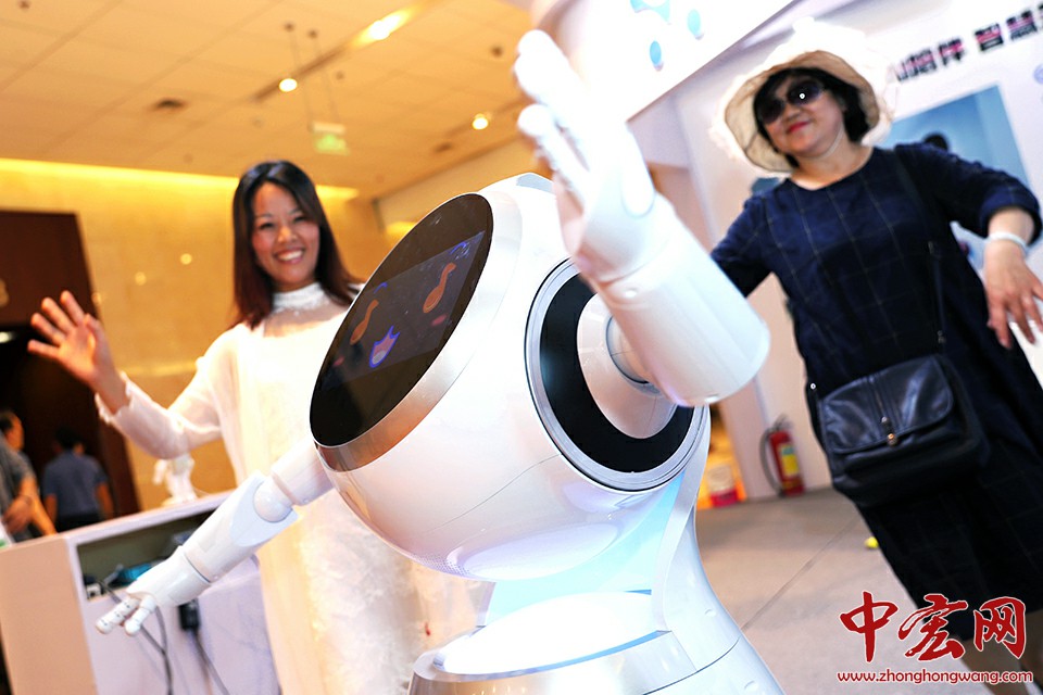5月30日，中医药健康养老服务展台的智能机器人与参观者互动。中宏网记者 王悦摄