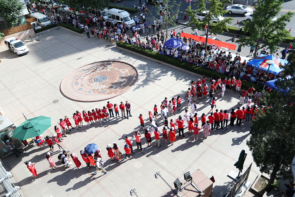 6月7日，人大附中校门前，前来送祝福的老师与学生击掌鼓励。中宏网记者 王悦摄