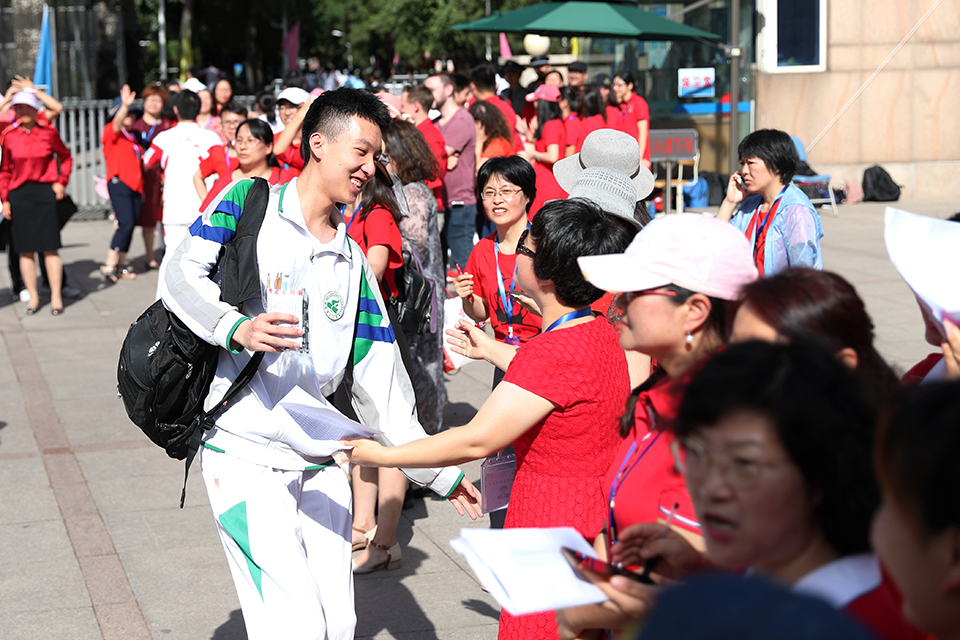 6月7日，人大附中校门前，前来送祝福的老师与学生击掌鼓励。中宏网记者 王悦摄