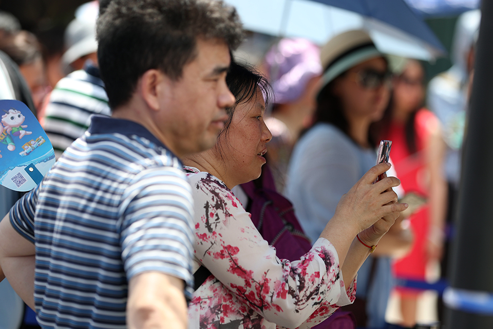 6月7日，一位家长用手机记录下自己孩子走出考场的珍贵画面。中宏网记者 王悦摄