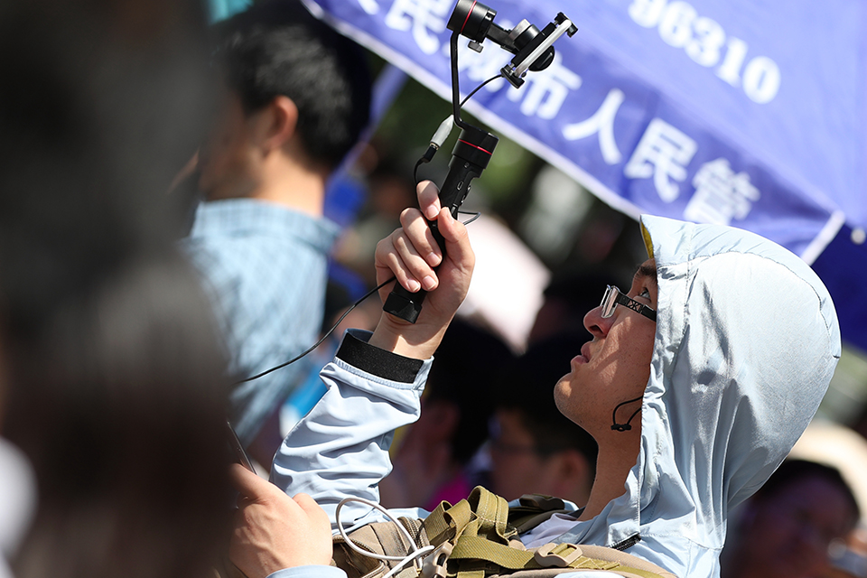 6月7日，媒体同行在烈日下直播北京高考。中宏网记者 王悦摄