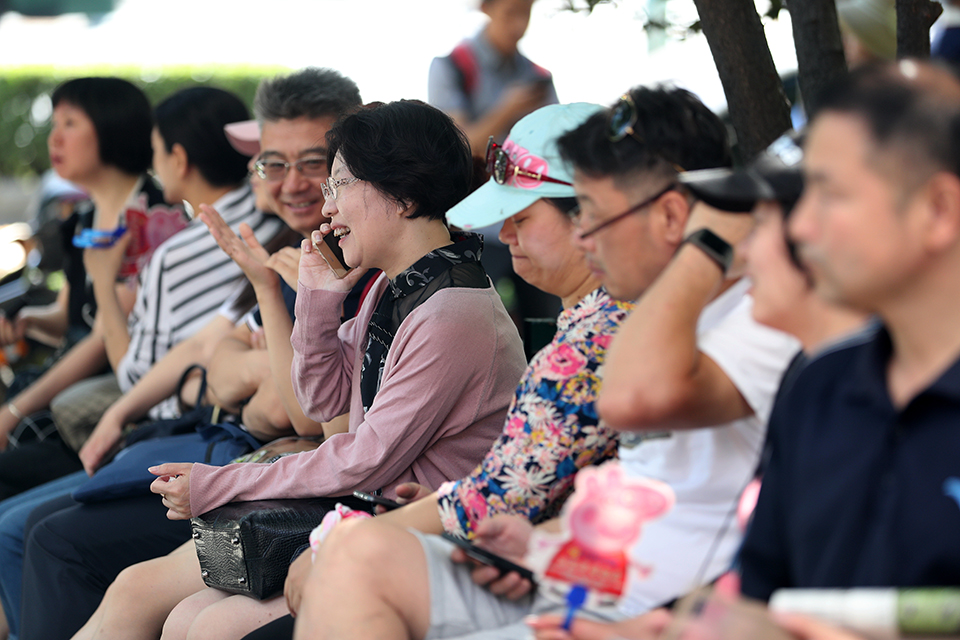 6月7日，校门外，学生家长在长椅上交流着教育经验。中宏网记者 王悦摄