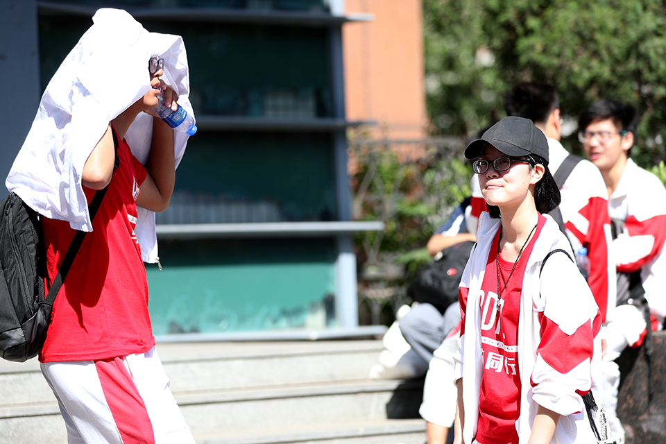 6月7日，前来送祝福的学生在校门外相互交流。中宏网记者 王悦摄