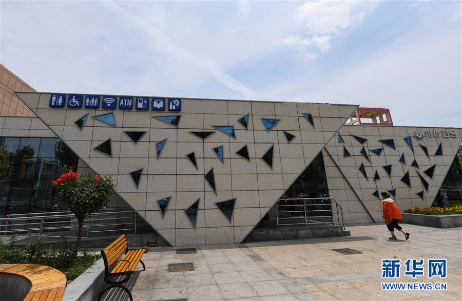 这是宿迁市张家港实验小学“街坊公舍”外景(6月26日摄)。<br/>
从2013年起,江苏省宿迁市大力实施“厕所革命”,先后在106座公厕安装厕纸机和投放厕纸,在48座公厕中安装婴儿护理台和婴儿座椅,在城市核心区23座公厕配套急救包、打气筒等应急设备。此外,进一步创新公厕建设理念,拓展公厕便民服务功能,充分利用公厕的多余空间——通过“试点先行”的办法,建设了27座具有综合服务功能的第三代公厕,统一命名为“街坊公舍”。<br/>
“街坊公舍”内设有免费WiFi、自动存取款、自动售卖、电子阅览、手机充电、电动擦鞋、饮水机、电视机等综合服务设施设备,并根据公厕的区位和环境,相应配套建设了图书阅览室,安装配套桌椅。“街坊公舍”开放后,每天吸引不少居民前来看书、读报、看电视,成为市民休闲放松的“驿站”。据悉,截至2017年底,宿迁市区范围内免费开放的公厕达578座,基本达到商业休闲区不出100米、居住区域不出300米、主次干道沿线不出500米就有一座公厕
