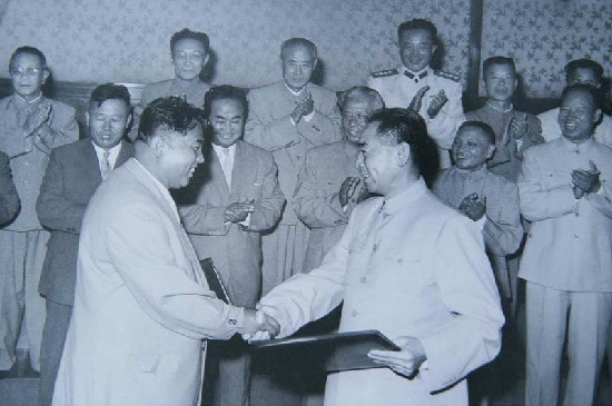 1961年7月11日，《中朝友好合作互助条约》在北京签订，同年9月10日起生效。《条约》决定双方根据国际主义原则，进一步加强友好合作，维护亚洲和世界和平；一方受到武装进攻，另一方立即尽其全力给予军事及其它援助；双方不参加反对对方的同盟、集团、行动或措施；发展经济、文化、科技合作，给予经济、技术援助等。图为周恩来总理与访华的金日成首相在《中朝友好合作互助条约》上签字后互换文本。