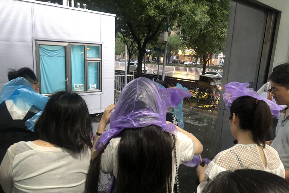 人们纷纷穿上地铁工作人员送上的雨衣。