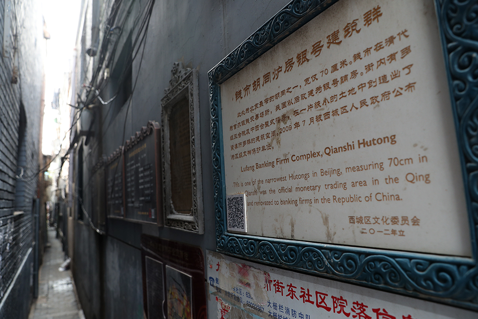 中宏网8月20日电（记者 康书源）钱市胡同，位于西城区大栅栏北面的珠宝市街西侧，是北京最窄的胡同。胡同全长五十五米，平均宽零点七米，最窄处仅零点四米，一步就能从自家门内迈入胡同对面人家的院里，两人对面走过都要侧身而行，一个人推着一辆自行车就难以通行了。然而，这条仅50米长的死胡同却是北京最早的“金融街”，拥有一片银号群。100多年前，北京官办的白银铜钱买卖就集中在这条胡同里，这里垄断着北京城白银铜钱的交易。
