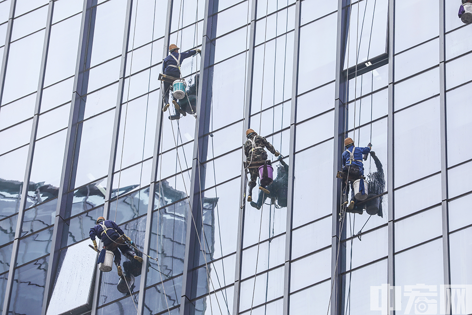 9月12日，在北京西站附近的一处写字楼，数名“蜘蛛人”系着保险绳，悬吊在距地面数十米的高空处，对写字楼玻璃外墙进行清洁。 中宏网记者 富宇 摄