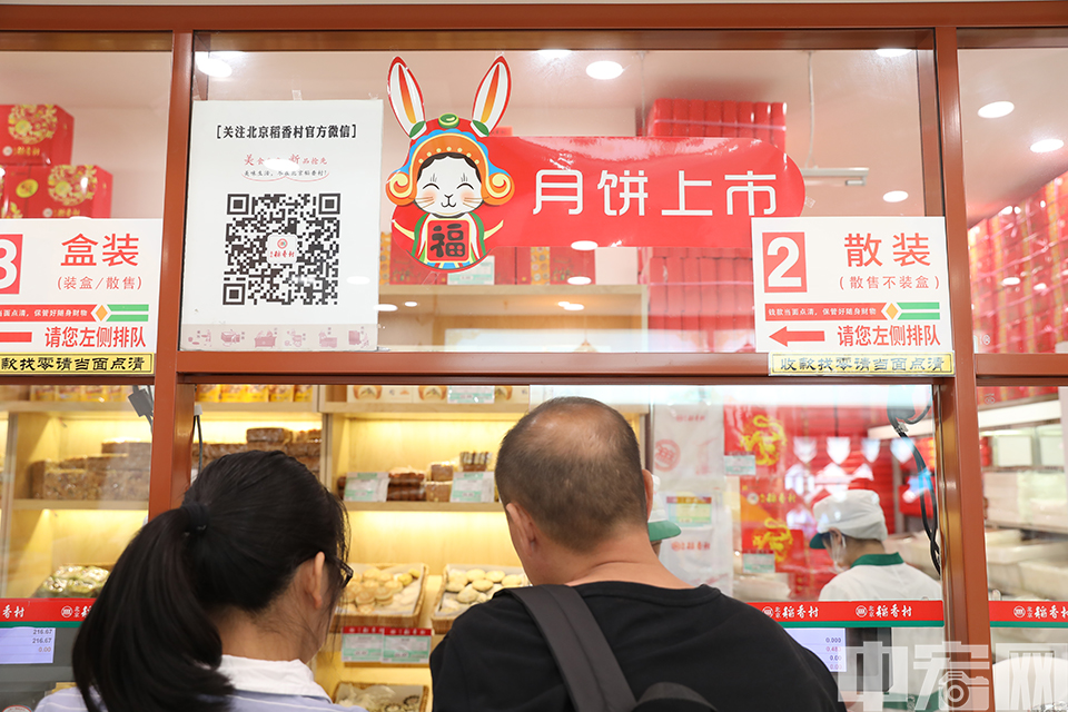 记者走进北京一家稻香村门店，见到不少前来购买月饼的市民。图为稻香村店内贴着月饼上市的广告。 中宏网记者 富宇 摄