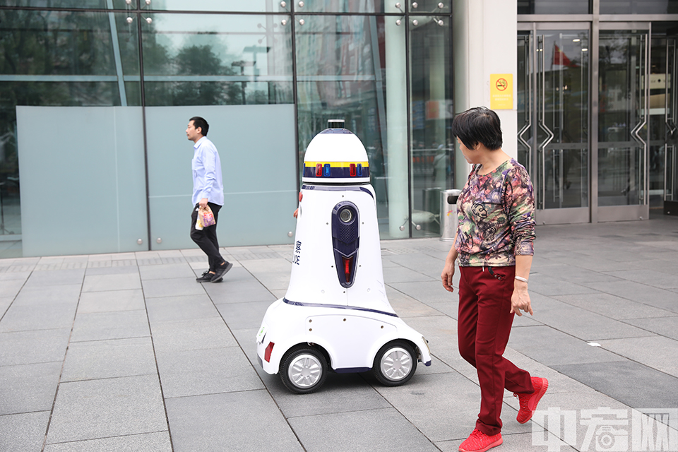 9月27日，在北京西单商业区，一台机器人“警察”出现在来往的人群中“上岗执勤”，吸引了众多市民驻足。记者在现场看到，这台机器人上装有摄像头，扬声器，照明灯，报警灯和轮子等，显得科幻风十足。据了解，这款警用机器人是由公安部第一研究所研制。 中宏网记者 富宇 摄