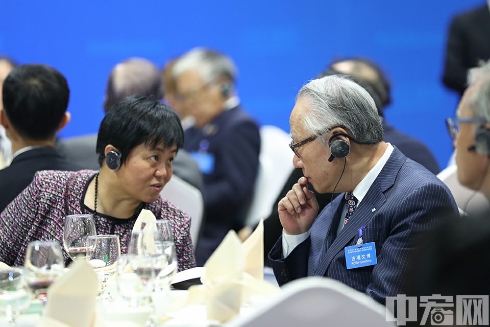 10月12日，第四轮中日企业家和前高官对话全体会议及闭幕午餐会在北京召开。图为两名日本参会代表讨论中。中宏网 康书源 摄