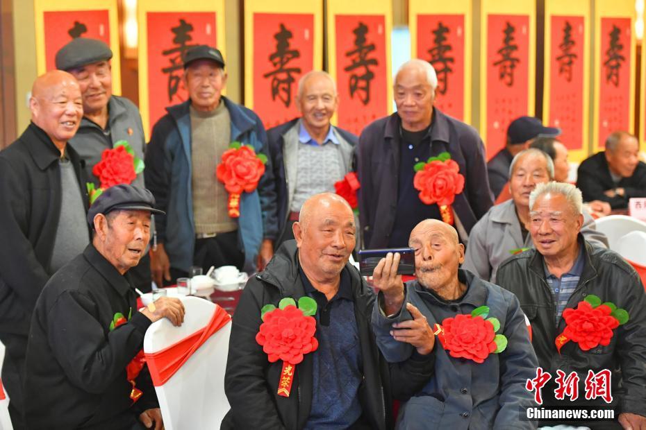10月15日，中国传统节日“重阳”来临之际，河北石家庄西兆通镇的百余位80岁以上的老人乐享“百叟宴”，并收到祝“寿”字，开心地迎接自己的节日。图为一位94岁的老人拿手机自拍纪念。中新社记者 翟羽佳 摄