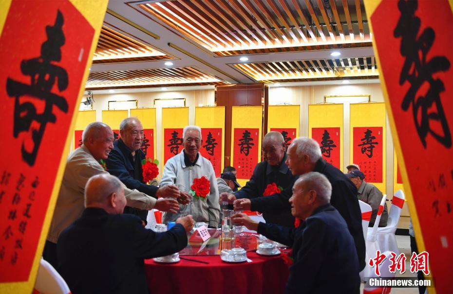 10月15日，中国传统节日“重阳”来临之际，河北石家庄西兆通镇的百余位80岁以上的老人乐享“百叟宴”，并收到祝“寿”字，开心地迎接自己的节日。图为老人们开心地举杯庆祝。中新社记者 翟羽佳 摄