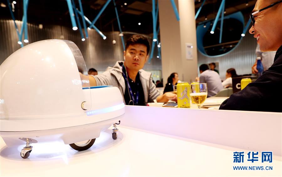 10月15日，顾客从送餐机器人的装载平台上取下菜品。 新华社记者 方喆 摄