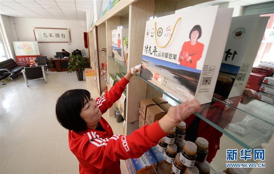 付凡平在位于宜川县城自己公司的实体店里整理展示柜（10月16日摄）。新华社记者刘潇摄