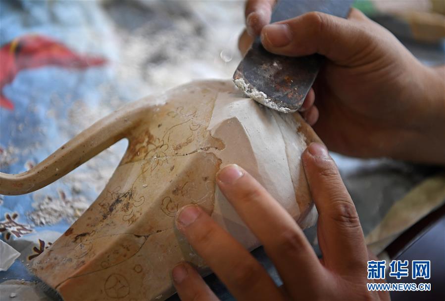 10月18日，在江西景德镇，工作人员修复一件瓷器。  新华社记者 万象 摄 图片来源：新华网