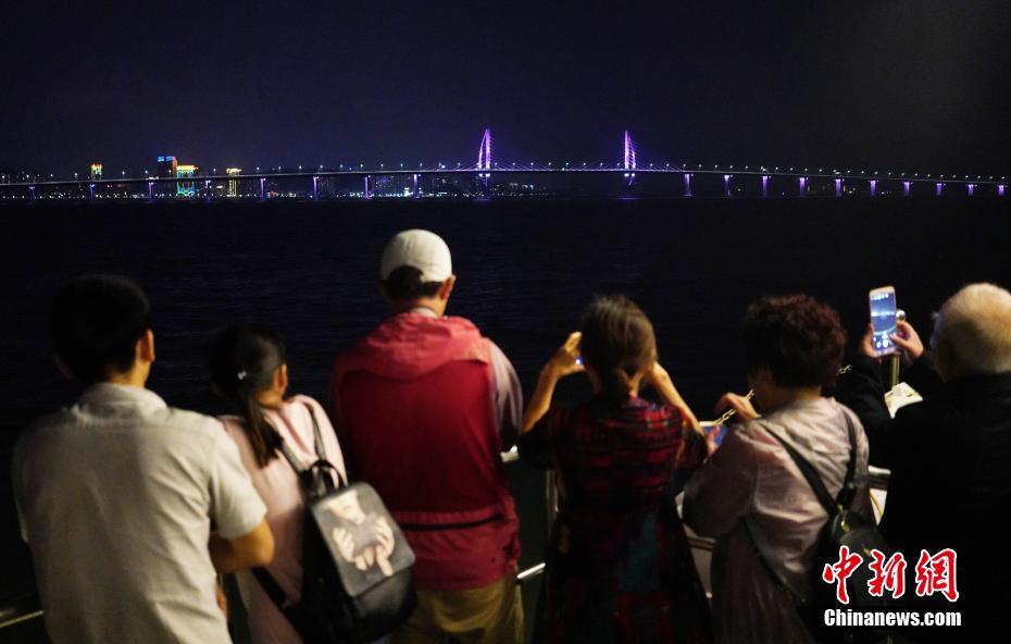 10月22日晚，游客在珠海乘坐游船近距离观赏即将通车的港珠澳大桥。港珠澳大桥即将于24日上午通车。 中新社记者 张炜 摄