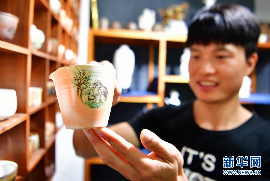 10月23日，王代丁在自己的陶艺工作室内展示自己设计创作的陶瓷公道杯。  新华社记者魏培全摄