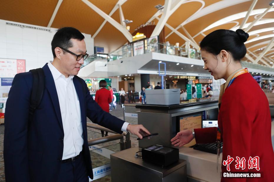 10月29日，搭乘国泰航空KA803航班，从上海前往香港的旅客张廉，凭着国泰航空网上值机的二维码，顺利完成了在浦东T2的出境、安检、登机手续，全程只花了10分钟。他成为中国内地机场首位通过无纸化方式值机、过检、登机的旅客，浦东机场也成为内地首家推出出境旅客无纸化便捷出行的机场。中新社记者 殷立勤 摄 图片来源：中新网