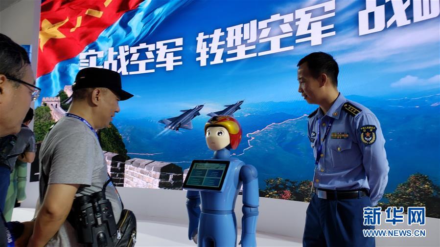 在航展中国空军招飞展台，参展观众和招飞宣传智能机器人“飞飞”互动交流（11月7日摄）。 新华社记者 李刚 摄 图片来源：新华网