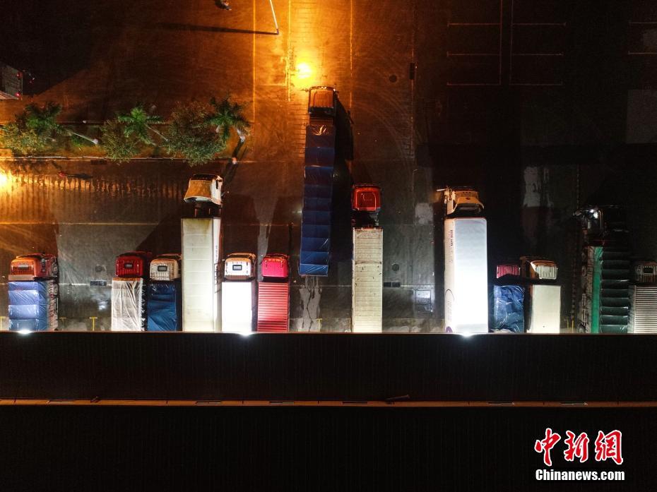 11月15日凌晨1时许，为应对“双十一”购物节后的快递派送高峰，广西柳州市某物流园内的快递企业正在全力分拣快递包裹，现场灯火通明。根据快递企业负责人介绍，其企业已经连续数天24小时“超长待机”工作，每天进出港的货物有数十万件。图为物流仓库一侧的卸货空位上整齐停着十数辆运载快递包裹的卡车。王以照 摄