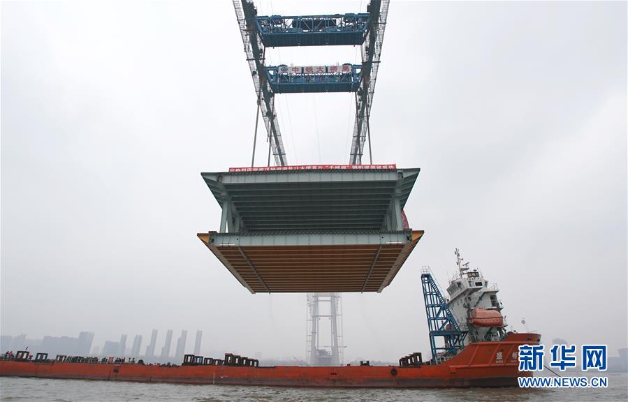 11月15日，缆载吊机在吊装重达1000吨的钢梁。 新华社记者 程敏摄 图片来源：新华网
