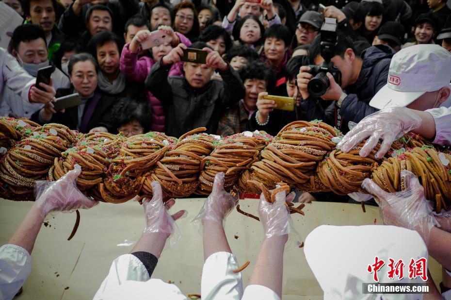 11月18日，天津麻花文化节在天津意式风情街桂发祥十八街麻花体验店举行，消费者共同分享了一支重118斤的巨型麻花。中新社记者 佟郁 摄 图片来源：中新网