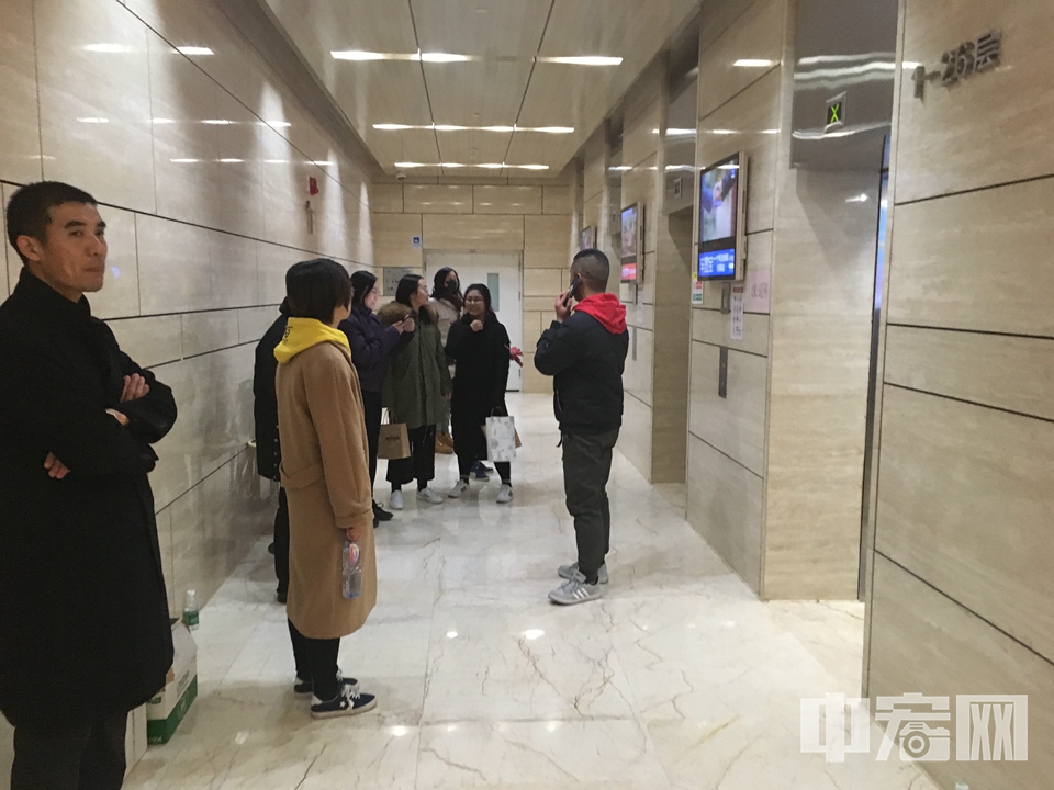 办理结束后记者返回一楼大厅，几位市民在等候电梯。 中宏网记者 富宇 摄
