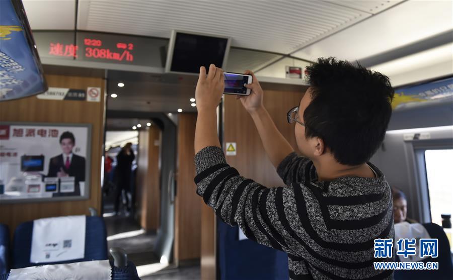 　12月17日，试乘乘客在济青高铁列车上拍照留念。  新华社发（董乃德 摄）