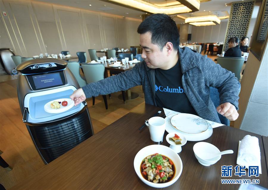 　　12月18日，智能送餐机器人在“未来酒店”里为顾客送餐。<br/>

　　当日，阿里巴巴首家“未来酒店”在杭州开业，这家酒店支持全场景身份识别，并大面积使用AI智能，顾客可通过人脸识别、语音控制、智能机器人等设备享受各种服务。<br/>

　　新华社发（龙巍 摄）