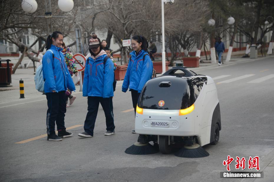 学生们关注无人驾驶清扫车。 中新社记者 刘文华 摄 图片来源：中新网