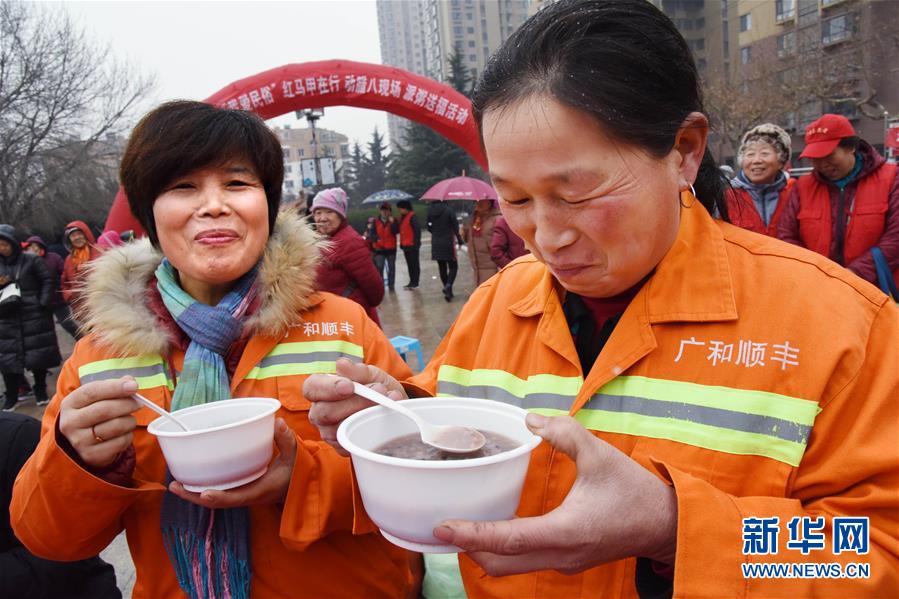 　　1月11日，两名服务社区的环卫工人在品尝社区居民送上的腊八粥。新华社记者 李紫恒 摄
