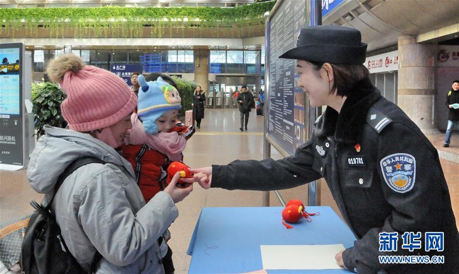 1月15日，北京铁路公安局西客站派出所的民警在给旅客赠送新春平安小礼物。新华社发（张元 摄）