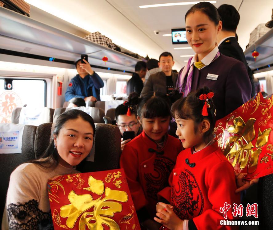 图为打扮成中国娃娃的小女孩在车厢内为旅客唱童谣。张秋瑾 摄 图片来源：中新网
