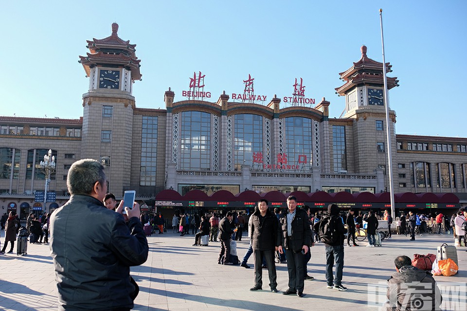 1月21日，北京火车站广场，在北京站前合影留念的旅客。