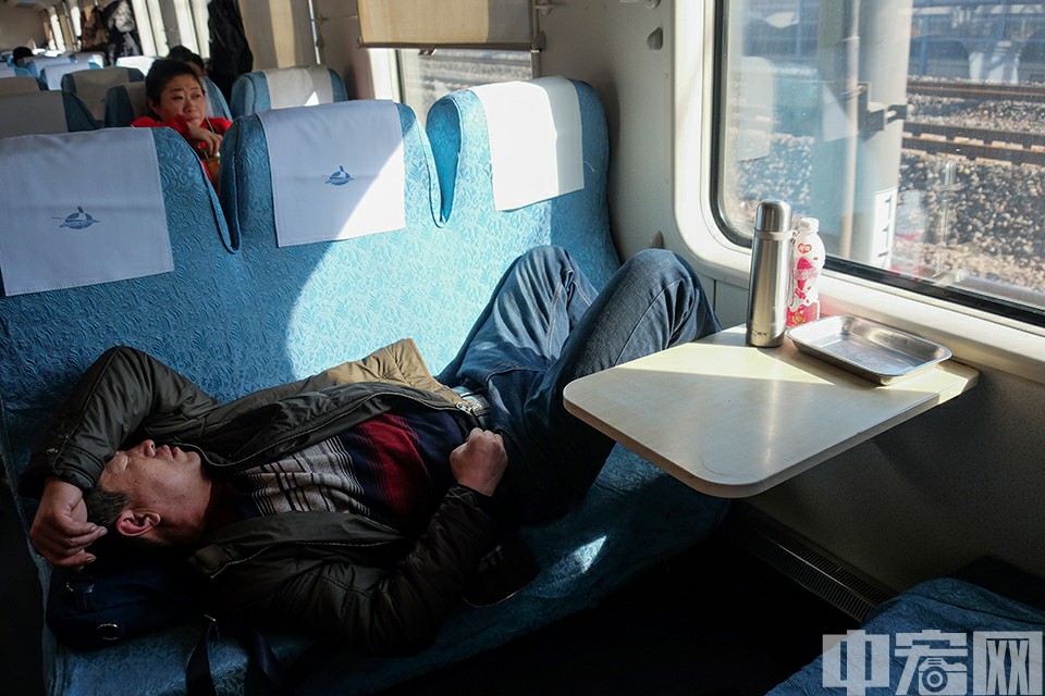 1月21日，K1301次列车，一名乘客在无人的硬座上躺下休息。