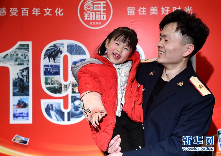 1月21日，一名体验者身穿铁路职工工作服怀抱孩子留影。新华社记者李安摄