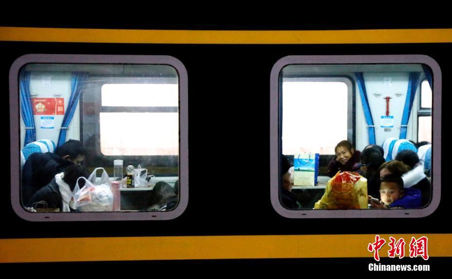 1月21日晚，2019年春运首日，在湖北宜昌火车东站，来自五湖四海的旅客乘坐火车返回家乡。列车在站台短暂停靠，列车里的乘客有的低头看书、看手机，有的向窗外张望，小孩子们一起打闹嬉戏，小小的车厢充满了旅客回家的喜悦，也成为他们临时而温暖的“家”。黄余洋 摄 图片来源：中新网