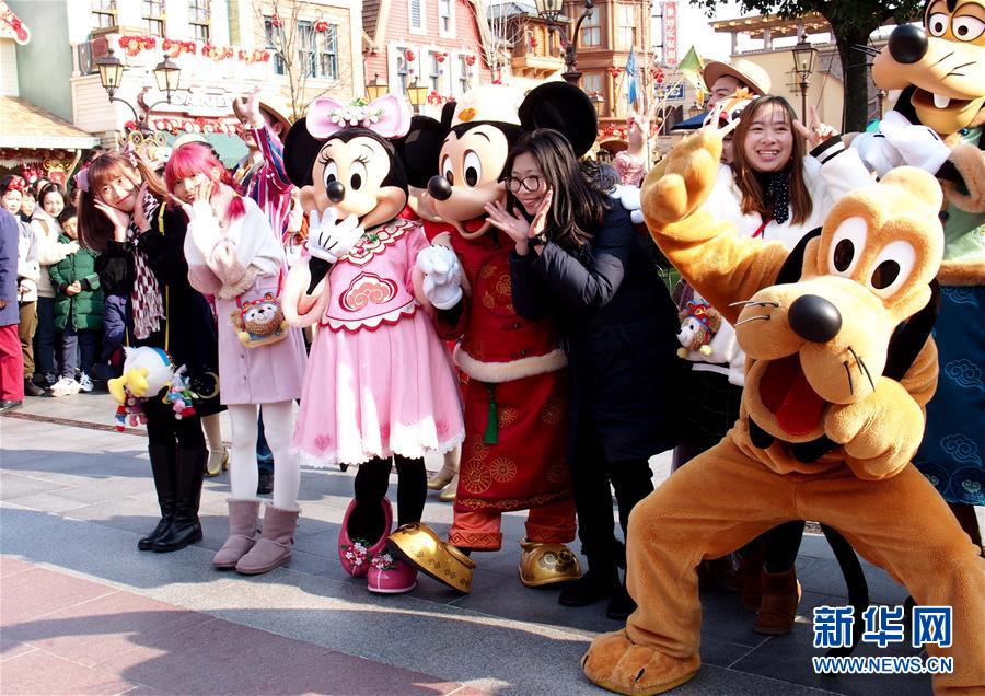 1月21日，游客在上海迪士尼乐园与米奇和他的小伙伴们合影。 为迎接2019农历新年，上海迪士尼度假区推出系列“新年大餐”，内容囊括娱乐演出、美食佳肴及各类特色年货商品。 新华社记者 任珑 摄