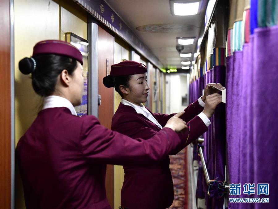 1月21日，贡久曲珍（左）提示妹妹旦增央金检查车厢设备。 在青藏铁路“唐竺古道号”Z6811次列车的乘务团队中，有一对藏族姐妹。姐姐贡久曲珍2007年参加工作，现在是该次列车的列车长；妹妹旦增央金2017年开始在列车上担任乘务员。从青海西宁到西藏日喀则的春运旅途上，姐妹俩用真诚的服务温暖着旅客的回家路。 新华社发（张龙摄）
