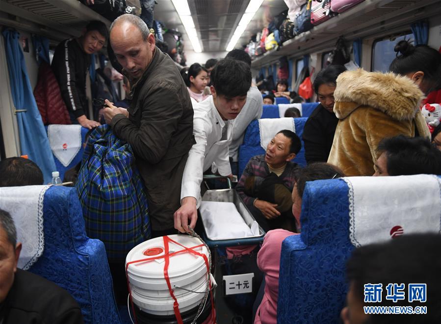 1月21日，在福建福州开往四川广安的K4186次临客列车上，炊事员郑祥军在拥挤的硬座车厢内为旅客送餐。 新华社记者 宋为伟 摄