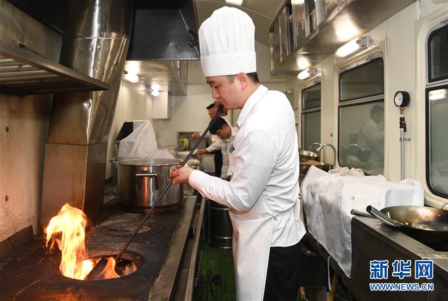 1月22日，在福建福州开往四川广安的K4186次临客列车上，厨师林炜为煤炉添煤。 新华社记者 宋为伟 摄