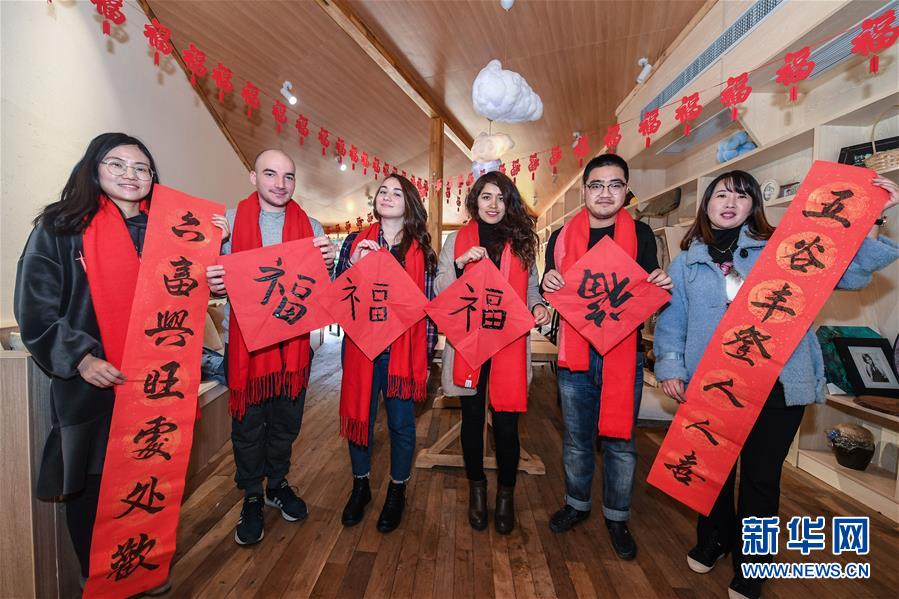 1月22日，留学生和临安当地百姓一起展示写好的春联。新华社记者 徐昱 摄
