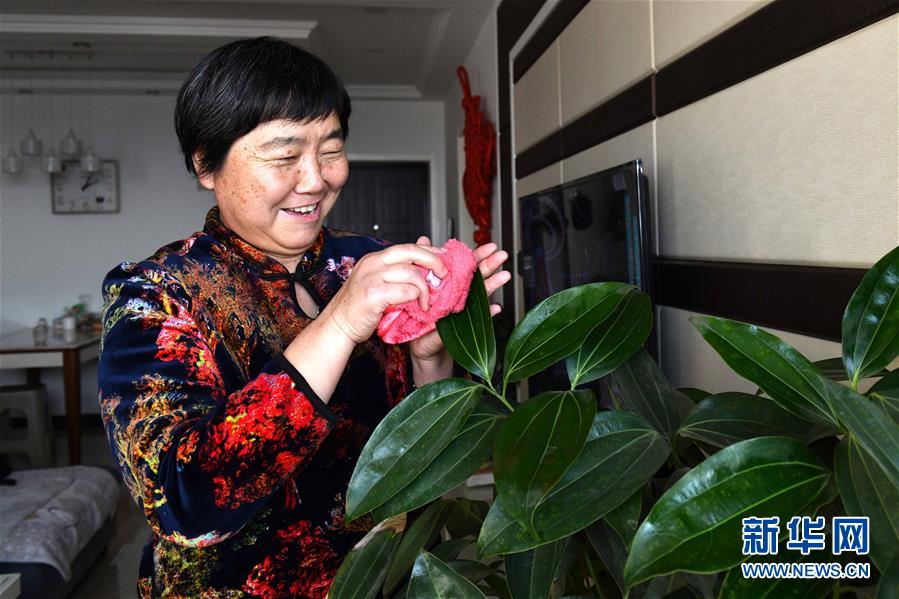 1月22日，“棉花姑娘”李爱荣在济南市章丘区双山街道的家中打理绿植。<br/>

　　新华社记者 郭绪雷 摄