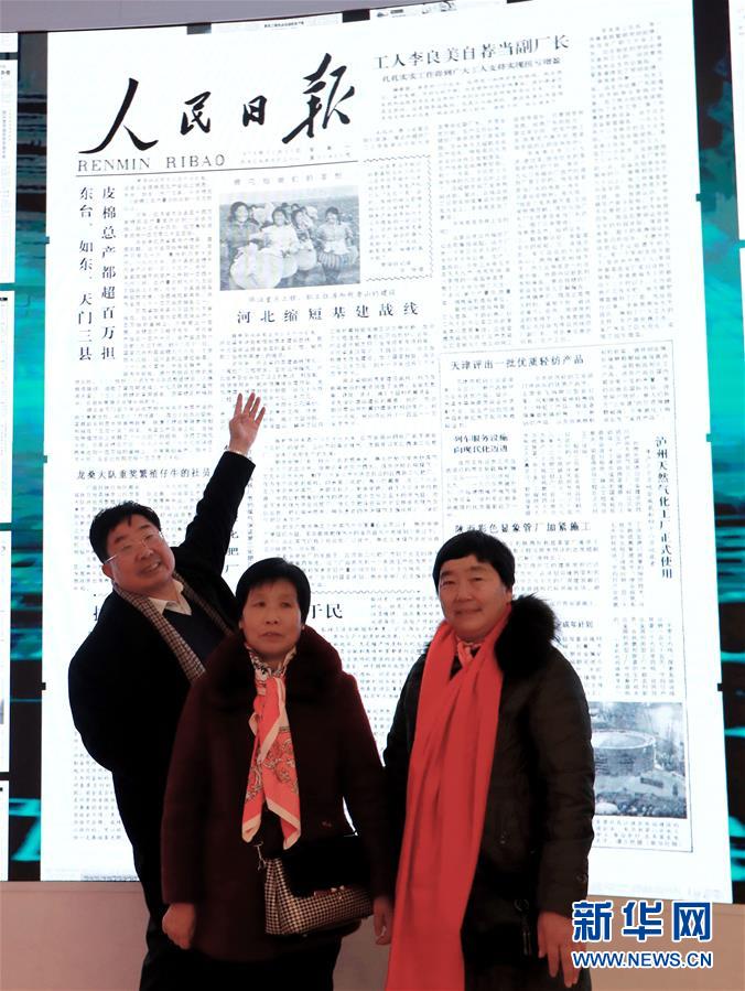 在北京中国国家博物馆，“棉花姑娘”李爱荣（右）、李爱在当年刊登有自己照片的《人民日报》前与当时采访她们的记者李锦（左）合影（2018年12月24日摄）。<br/>

　　新华社记者 潘旭 摄