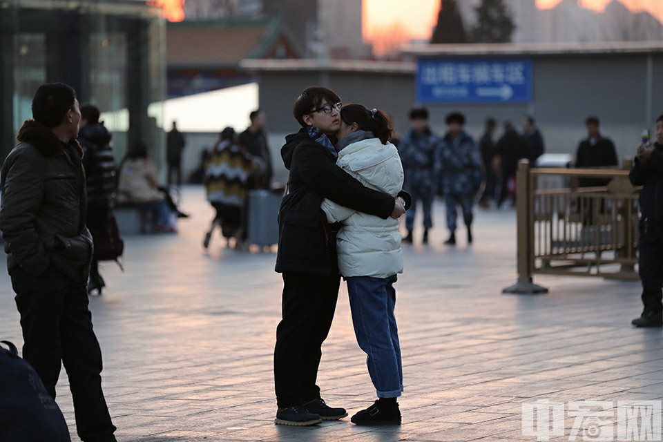 夕阳下的北京西站广场上，一对紧紧相拥不愿分别的情侣。中宏网记者 富宇 摄
